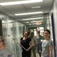 A group photo of the volunteers painting the walls.